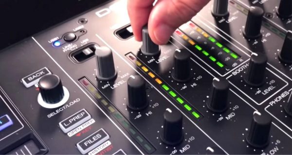 DJ adjusts volume on mixer