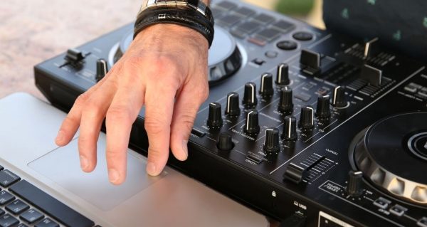 Controller DJ searches for music on laptop